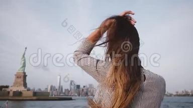 快乐的旅行者女人，头发随风飘扬，在自由女神像的纽约天际线上享受着缓慢的运动。