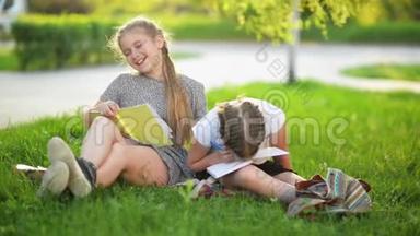 两个有趣的女孩在玩书。 他们在微笑，有很多乐趣。 天气晴朗。