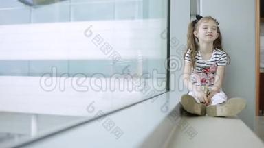 儿童在机场窗口附近看飞机，等待飞行时间