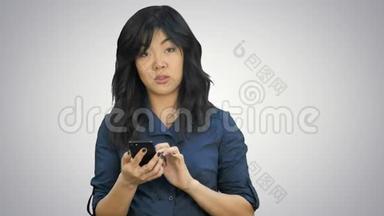 亚洲女商人在智能<strong>手机</strong>上阅读<strong>演示</strong>文稿，在白色背景下看相机