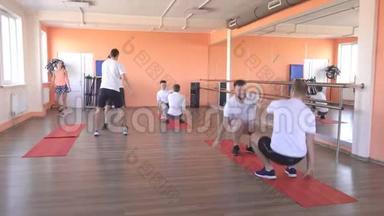 在一个现代化的健身中心里和白种人一起上课，在健身房里集体运动以增强肌肉和输球