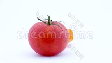 一整个大红番茄和一半的<strong>黄色</strong>番茄带水滴。 在<strong>转盘</strong>上慢慢旋转.. 孤立存在