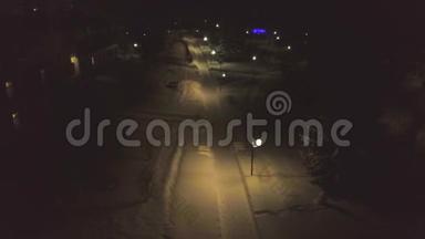 城市街道，雪覆盖的小路在夜晚被灯笼照亮。 剪辑。 美丽的黑夜，明亮的灯笼