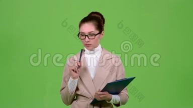 经理用一支笔在纸版上填写问卷。 绿色屏幕。 慢动作