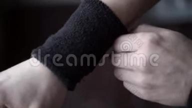 运动员戴黑色腕带。 行动。 运动员特写镜头调整手上的腕带，以免在比赛中伤腕