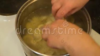 女人把饺子加入水里搅拌