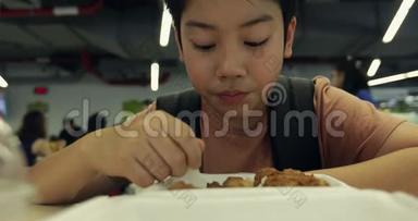 小亚洲男孩在食堂餐厅吃肉球和米饭。 小亚洲小孩吃肉球炒饭。