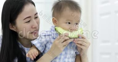 小亚洲男孩和妈妈一起吃瓜果照顾。