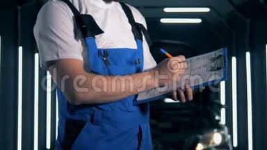 机械师在剪贴板上的纸上写字，关门。