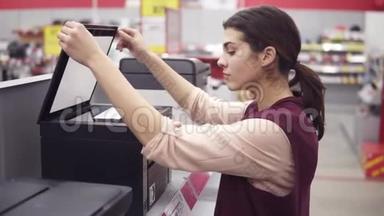 女客户在电器商店电子部选择新打印机。 <strong>接下来</strong>是一场展示会