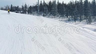 冬季在针叶林附近的跑道上，滑雪坡的特写和穿黄色夹克的人滑雪。 录像。 滑雪胜地