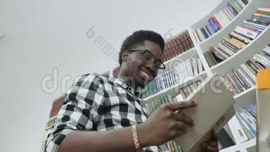 非洲男学生在大学<strong>图书馆</strong>站在梯子上<strong>看书</strong>。