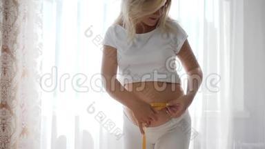 妈妈，孕妇用卷尺测量她的大肚子