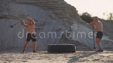 两名男运动员一起训练，在山上的<strong>沙</strong>滩上用<strong>锤</strong>子敲打着方向盘。 耐力