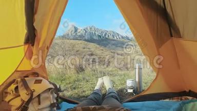 露营的女人躺在<strong>帐篷</strong>里，穿着登山靴，在度假时放松。 从<strong>帐篷</strong>的角度