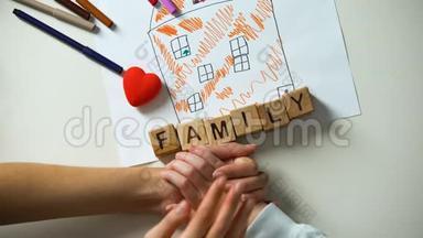 儿童牵着成人的手，家庭的文字由房子图片上的立方体制成