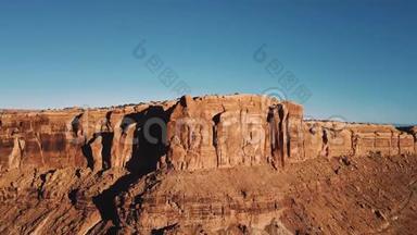 无人机在山岭之上升起，展现出史诗般的阳光沙漠荒野，拥有令人叹为观止的岩石悬崖峡谷天际线。