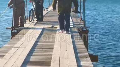在海滨小镇上的一个木码头上有钓竿的渔民。