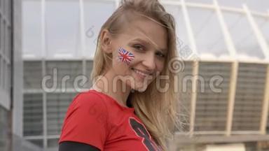 英国一个金发足球<strong>迷</strong>的年轻女孩，微笑着，像标志一样展示，冠<strong>军</strong>概念，体育场在
