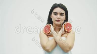 一位美丽的年轻女子站在看镜头的肖像。 用水果和口罩照顾你的身体