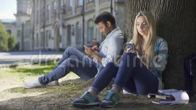 男，女陌生人<strong>坐在树下</strong>，用手机，女孩沉重地叹息