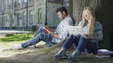 男人在<strong>树下看书</strong>，女孩用笔记本电脑，演员互相看