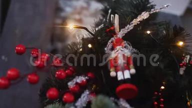 从挂在圣诞树上的红色套装的传统胡桃夹小雕像底部看灯和