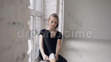 可爱的女孩<strong>芭蕾</strong>舞演员穿着<strong>芭蕾</strong>舞鞋靠近窗户在一个现代宽敞的<strong>芭蕾</strong>舞学校。 去运动，积极