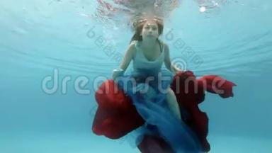 一个穿着连衣裙的漂亮少女在游泳池里游泳，在水面附近玩红蓝相间的布