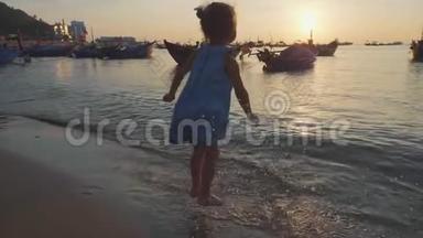 可爱的小女孩穿着一件连衣裙在海滩上<strong>溅起水</strong>花。