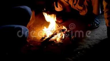 人们<strong>围坐</strong>在炉火旁取暖，在冬季夜景中观看城市景象