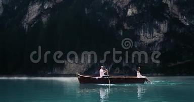 浪漫的<strong>情侣</strong>在湖中央，有一艘木船，男人在<strong>划船</strong>，他的女朋友在<strong>划船</strong>