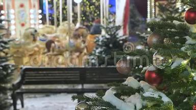 圣诞树装饰着城市。 在背景下旋转旋转旋转木马，孩子们骑在上面。 节日