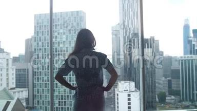 年轻女子<strong>走路</strong>的<strong>剪影</strong>，从办公室的窗户欣赏城市景色。 3840x2160