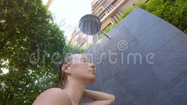 一个年轻女人在热带花园里洗澡的慢镜头。 在热带<strong>度假</strong>胜地<strong>度假</strong>的概念。 年轻女子