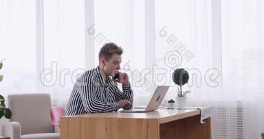 商务人员在办公桌上使用笔记本电脑时使用手机