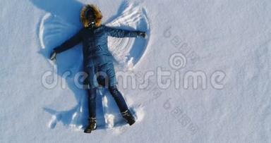 女人让<strong>雪天</strong>使躺在雪地里。 空中录像。