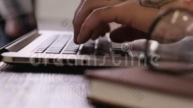 一个年轻人用手在笔记本电脑键盘上打字，完成工作，合<strong>上上</strong>网本。