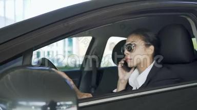 戴墨镜的女士坐在车里，用手机说话，警察