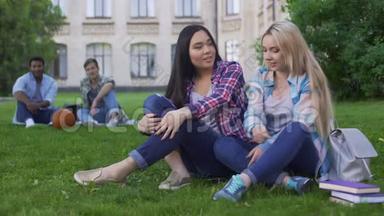 学生们，坐在草坪上讨论新衣服的混血朋友
