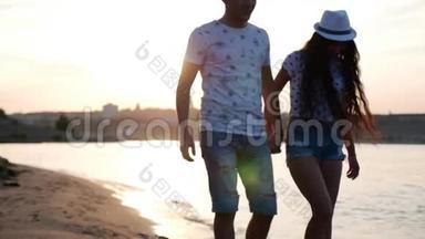 幸福夫妇牵着手漫步在岸边，赤脚在沙滩上踏着海浪，拥抱着。