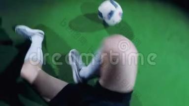 职业足球运动员坐在地板上，站起来，开始戏耍，从上面看，摄像机在他身上