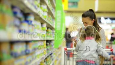 家庭购物概念。 《微笑的女人和女孩在<strong>食品店</strong>挑选产品的肖像》。