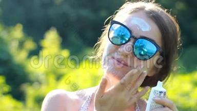 一位年轻的女士正在从阳光下涂上防晒霜。