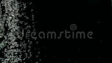 落雨滴在黑色背景上缓慢运动的镜头。 水滴落在黑色背景上。