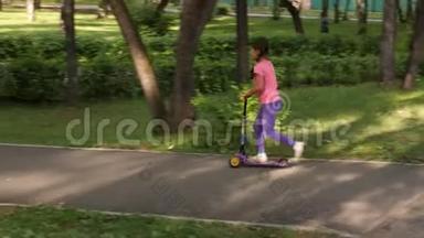 夏天，小孩子在公园里骑滑板车。 可爱的女孩在户外玩耍。 儿童休闲和户外运动