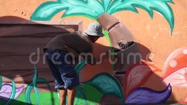 墙画家在混凝土墙上画一棵椰子树。
