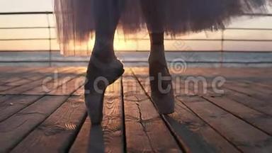 <strong>托起</strong>芭蕾舞演员`脚，在靠近大海的人行道上热身，踮<strong>起</strong>脚尖。 太阳照耀着