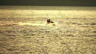日落时分，两个人在海上乘坐喷气式滑雪板。 慢镜头