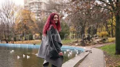 迷人的女人，红头发，在一个有人工湖的公园里<strong>走来走</strong>去。 她转过身<strong>来</strong>，微笑着<strong>走</strong>向